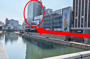博多橋を渡って左に曲がり、川沿いを直進ください。