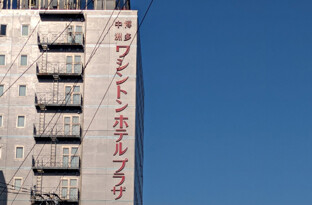 川沿いの左側を進むとホテルがございます。赤色のネオンが目印です!